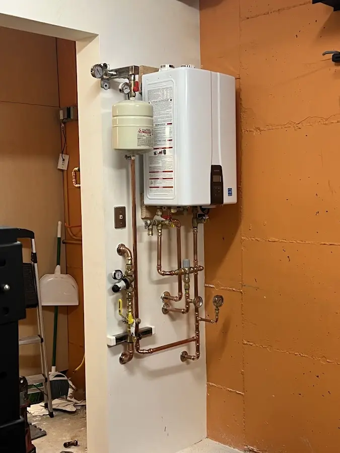 Plumbing technician inspecting water heater connections in Hanover